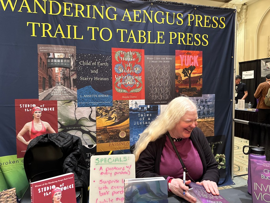 Chrys Buckley signing advanced reader copies of Invisible Violets at the Wandering Aengus Press booth at the Portland Book Fest